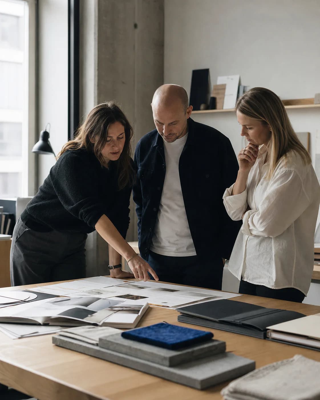 Et byråteam som går gjennom kundearbeid sammen i et kreativt studio